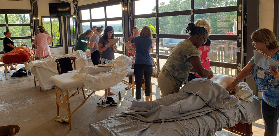 10 Reasons to Learn Raindrop from a CARE Instructor 4 CARE Instructors checking each other's Raindrop and Vitaflex skills at CCI Summit